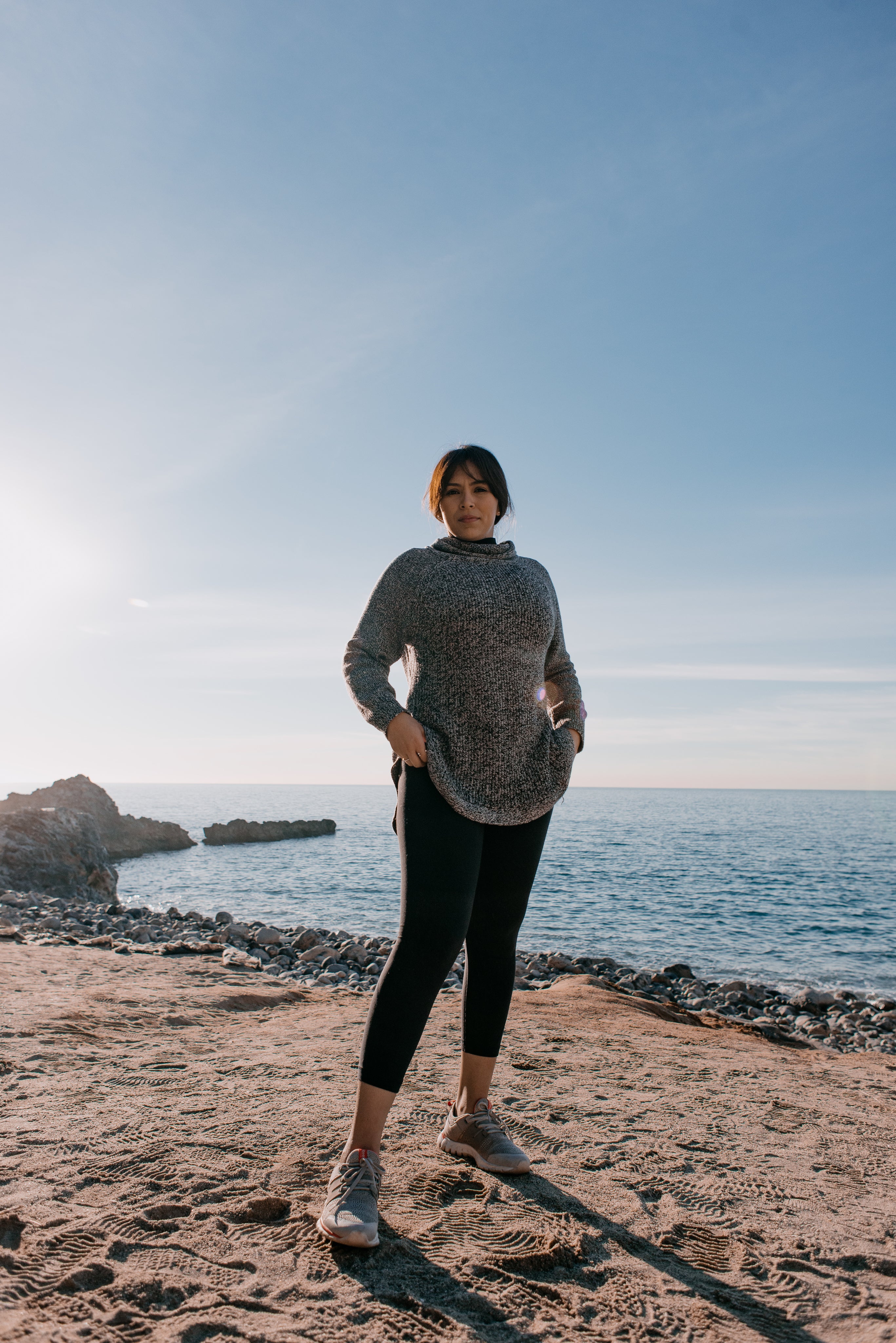 woman-in-sports-clothes-stands-on-a-beach-in-the-morning-light.jpg